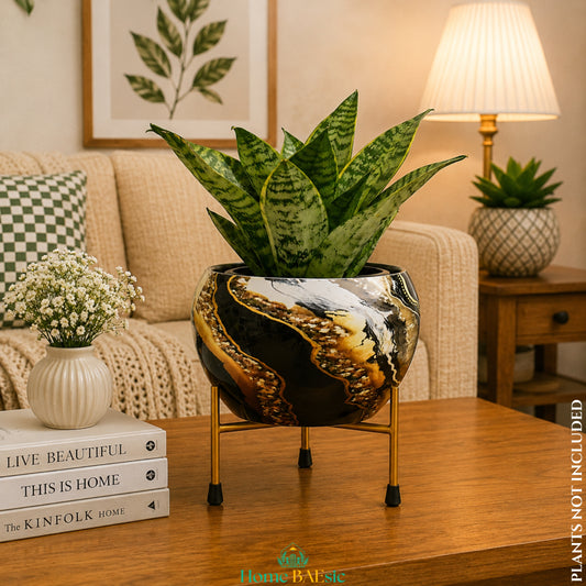 Black marble gold planter with indoor plant on a gold metal stand styled in a modern living room