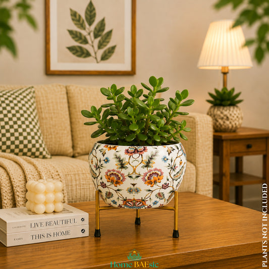 Blossom Paradise floral metal planter with lush jade plant on golden metal  stand in a warm modern living room on a wooden coffee table in a cozy living room setting.