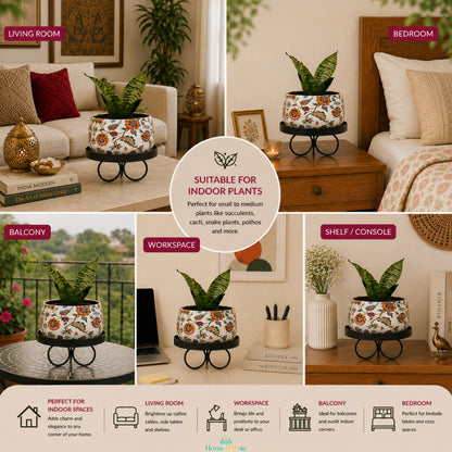 Blossom Paradise floral metal planter with black tray stand styled with a snake plant across a living room, bedroom, balcony, workspace, and shelf or console.