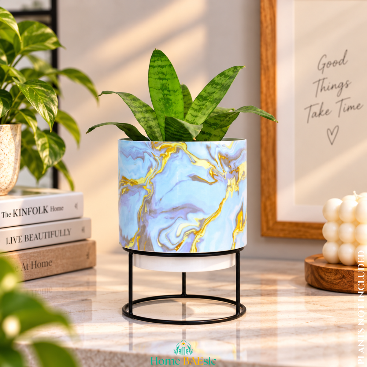 Blue & Gold Marble designer metal tumbler planter with stand, featuring elegant blue, turquoise, white and gold marble artwork with a green indoor plant, styled as a sophisticated home decor accent.