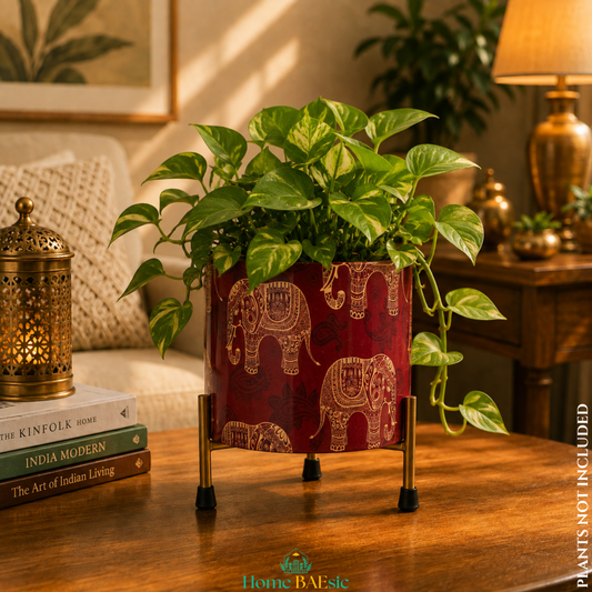 Red and gold Elephant Motif metal planter with a lush green pothos plant on a sturdy metal stand, styled as an elegant home décor accent