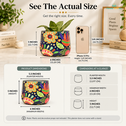 See the actual size of the Home BAEsic Flower Doodle Tumbler planter, shown beside an iPhone 15 Pro for scale, with dimensions of 5.5-inch planter mouth, 6-inch maximum width, and 5-inch height. Plants and decorative props are not included; planter does not come with a stand.