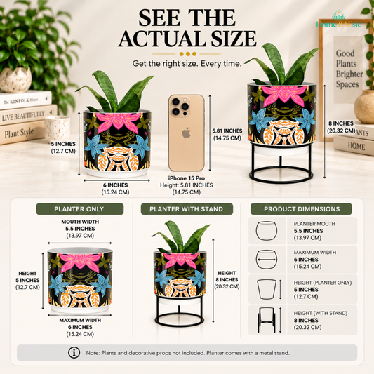Size infographic for the Home BAEsic Floral Fantasy Tumbler metal Planter, showing the colorful floral planter with and without its black metal stand alongside an iPhone 15 Pro for size comparison. The planter measures 5 inches high, 6 inches wide, with a 5.5-inch mouth, and measures 8 inches high with the stand. Product dimension callouts show the planter mouth, maximum width, planter-only height, and height with stand. Plants and decorative props are not included; planter comes with a metal stand