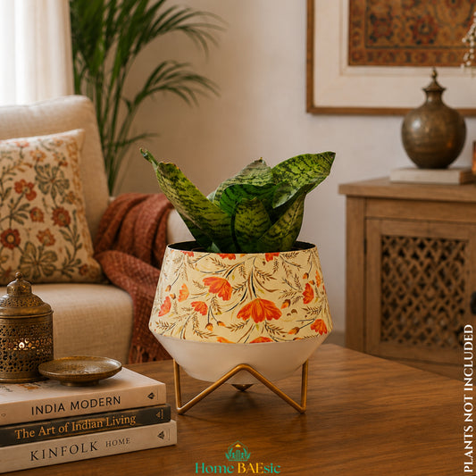 Happy Poppy floral metal planter with orange flower design and golden stand styled with an indoor snake plant in a modern Indian living room