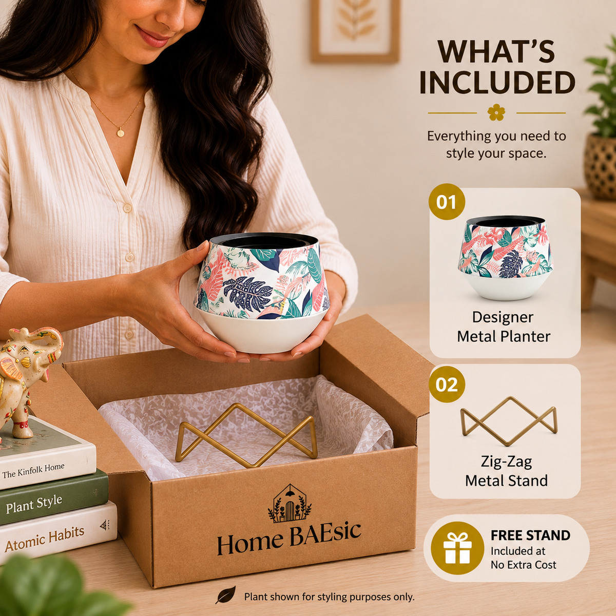 A woman holds a floral metal planter above an open Home BAEsic box containing a gold zig-zag metal stand, with an inset graphic listing what is included.